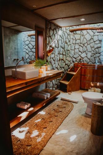 a bathroom with a sink and a toilet and a tub at Pousada Jardim do vento in Icaraí
