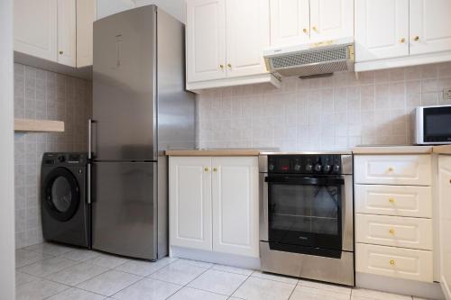 a kitchen with a refrigerator and a dishwasher at Spacious apartment close to the sea and the city center in Athens