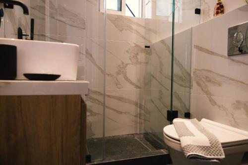 a bathroom with a toilet and a glass shower at Spacious apartment close to the sea and the city center in Athens