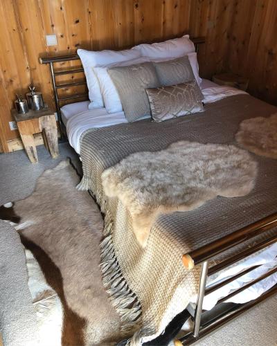 - une chambre avec un lit doté d'une couverture en fourrure et d'oreillers dans l'établissement Alpine Retreat with Mont Blanc View, Chamonix, private parking, à Chamonix-Mont-Blanc