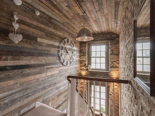 a staircase in a room with wooden walls and a clock at Newgate Loft in Morpeth