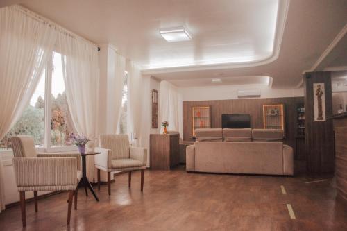 ein Wohnzimmer mit einem Sofa und einem TV in der Unterkunft Hotel Colina São Francisco in Gramado