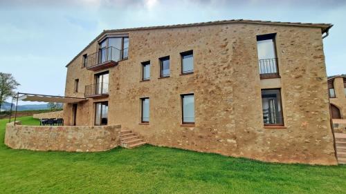 an old brick building with a stone wall at El Guitart - Turisme Rural in Ripoll