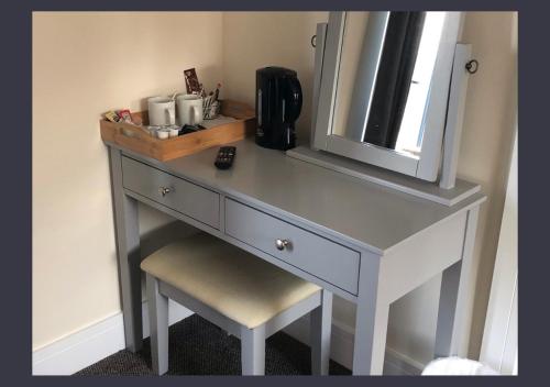 a dressing table with a chair and a mirror at Chevin End Guest House in Otley