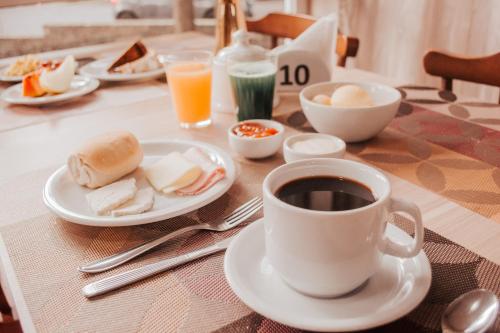 格拉玛多Hotel Colina São Francisco的餐桌,茶几,咖啡和一盘食物