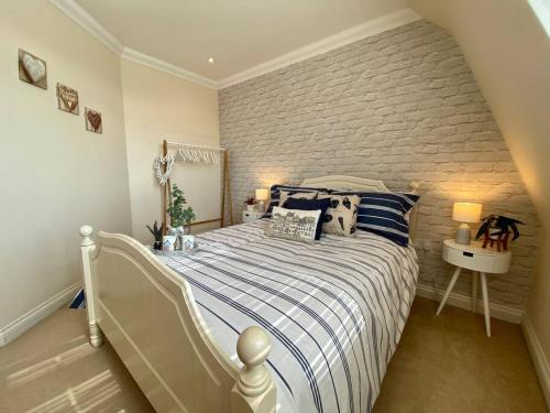 a bedroom with a bed and a brick wall at Coastal Mews House close to Beach in Felixstowe