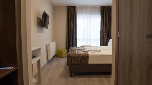 a hotel room with a bed and a window at Budapest Airport Eprespark Hotel in Vecsés
