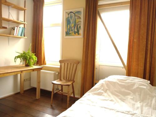 Schlafzimmer mit einem Schreibtisch, einem Stuhl und einem Bett in der Unterkunft Logies de Zeeuwse Klei, een gezellig jaren 30 huis in Middelburg