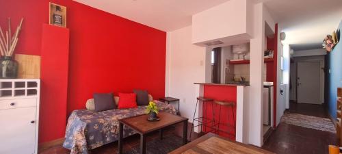 um quarto com paredes vermelhas, uma cama e uma mesa em Loft a metros Peatonal sarmiento em Mendoza