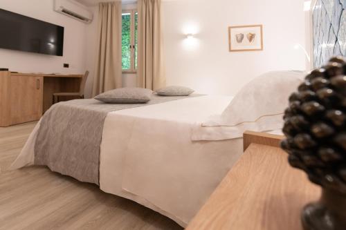 a bedroom with two beds and a flat screen tv at Splendid Hotel Taormina in Taormina