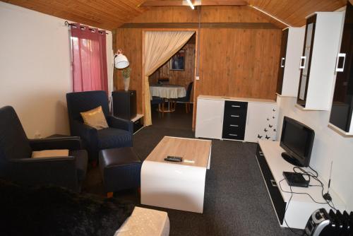 een woonkamer met een tv en een bank en een tafel bij Gästehaus Kevin Schult in Berlijn