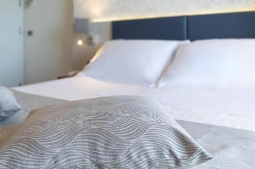 two beds in a bedroom with white sheets and a blanket at Splendid Hotel Taormina in Taormina