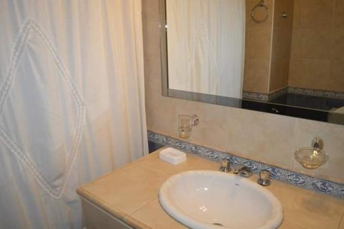 a bathroom with a sink and a mirror at Nuevo Hotel Magnet in Villa Carlos Paz