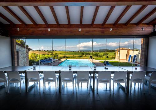 a dining room with a table and chairs and a large window at Borgo Solario in Castiglione del Lago