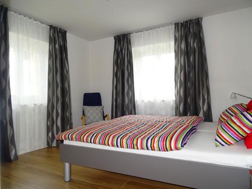 ein Schlafzimmer mit einem Bett mit einer bunten Decke darauf in der Unterkunft Ferienwohnung Litterscheid in Kiefersfelden