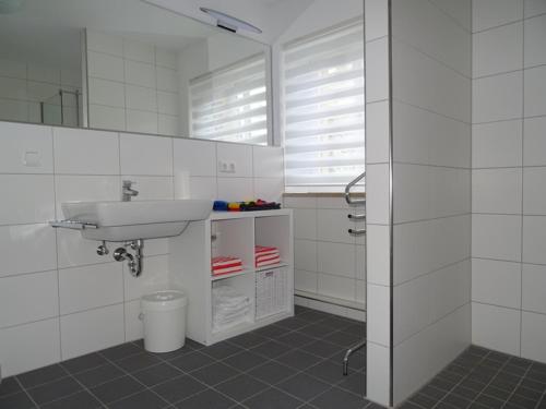 a white bathroom with a sink and a mirror at Ferienwohnung Litterscheid in Kiefersfelden