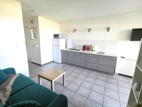a kitchen with a couch and a table in a room at Appartement Vue Mer 212 in Canet-en-Roussillon