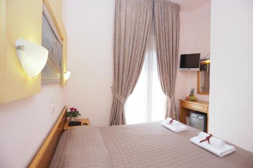 Un pat sau paturi într-o cameră la Aegeon Hotel