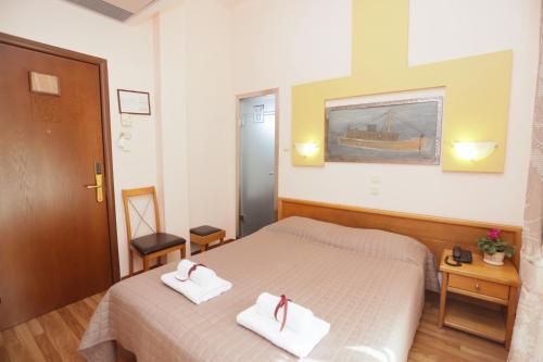 a bedroom with a bed with two towels on it at Aegeon Hotel in Thessaloniki