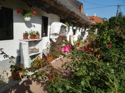 een wit huis met veel planten en bloemen bij Nádasház in Gyenesdiás