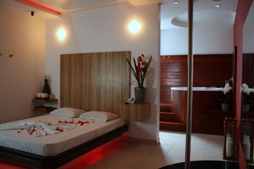 a bedroom with a bed with red flowers on it at Ápice Motel in Jaguariúna