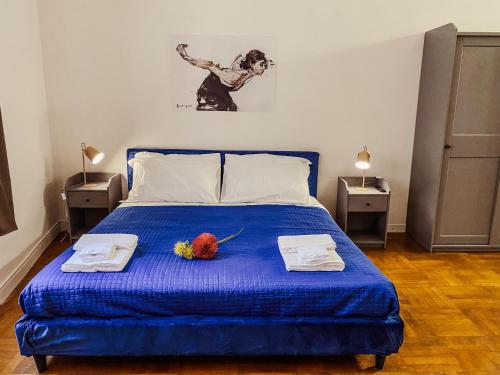 a bedroom with a blue bed with two towels at Residenza Studio delle Arti in Bologna