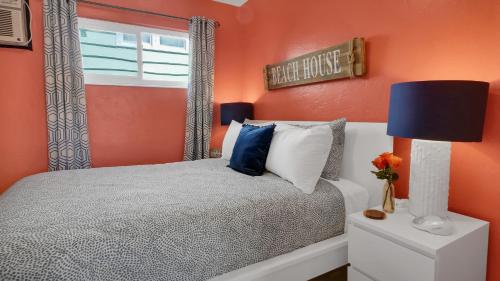 a bedroom with orange walls and a bed with a blue lamp at The Beach House - Treasure Island in St Pete Beach