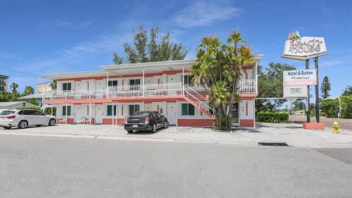 a pink and white building with a car parked in front at The Beach House - Treasure Island in St Pete Beach
