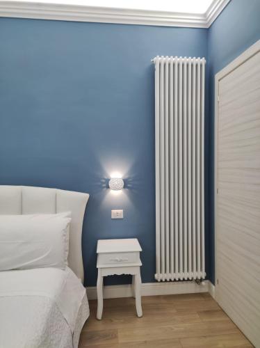 a blue bedroom with a bed and a white radiator at Porta d'Alpi in Latronico