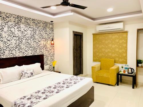 a bedroom with a bed and a yellow chair at Hotel oak by signature airport zone hyderabad in Shamshabad