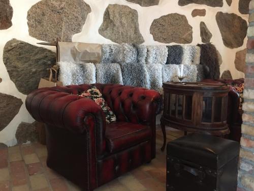 a living room with a couch and a stone wall at Munkagården Bed & Breakfast in Svalöv