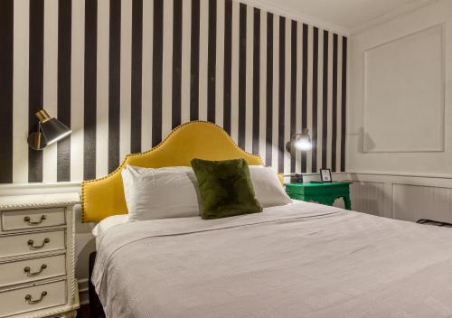 a bedroom with a white bed with a yellow headboard at New Hotel Collection Downtown St Pete in St Petersburg