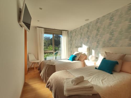 A bed or beds in a room at Sanxenxo Casa Rial 47 con PISCINA CLIMATIZADA