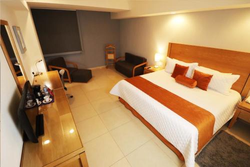 a hotel room with a bed and a chair at HB Córdoba in Córdoba