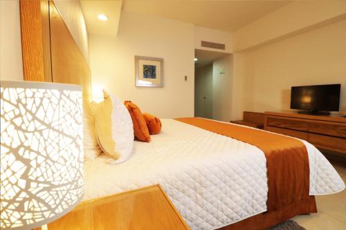 a bedroom with a bed with a television on a dresser at HB Córdoba in Córdoba