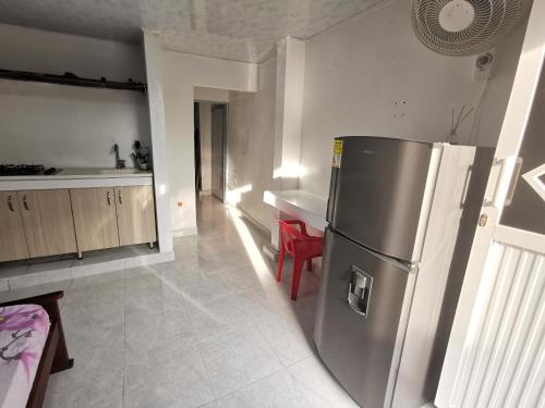 Una cocina con refrigerador de acero inoxidable y una mesa. en apartaestudio J.V.G., en San Andrés