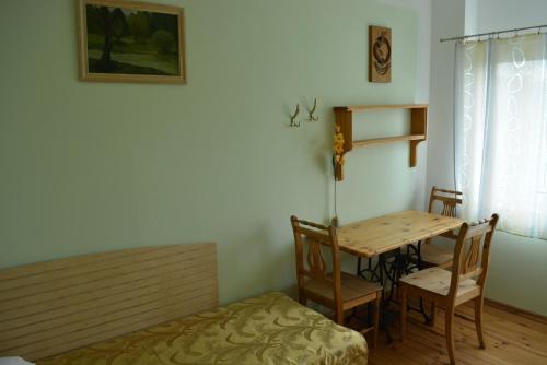 een kamer met een tafel en stoelen en een bed bij Viesu nams Jūras Bura in Tūja
