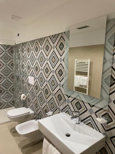 a bathroom with a sink and a toilet and a mirror at Alba Relais in Nemoli