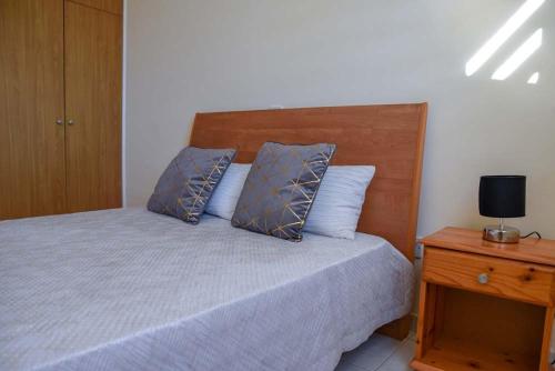 ein Schlafzimmer mit einem Bett mit zwei Kissen und einem Nachttisch in der Unterkunft Melania Gardens Apartment in Klorakas