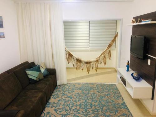 sala de estar con sofá y TV en Apartamento Praia de Palmas, en Governador Celso Ramos