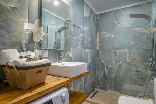 een badkamer met een wastafel, een spiegel en een wasmachine bij Orea Homes in Ammoudia