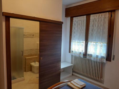 baño con ducha y aseo y ventana en B&B Casa Piva, en Serravalle
