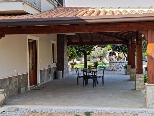 a patio with a table and chairs under a pavilion at Affittacamere Le Querce in Teggiano