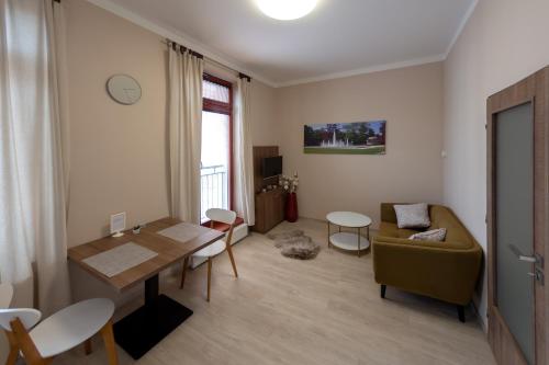 a living room with a table and a couch at Penzion Apartmány Resident in Poděbrady