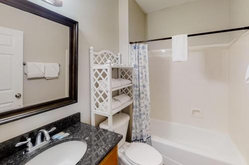 un bagno con lavandino, WC e specchio di Lotsa Dunes by Meyer Vacation Rentals a Fort Morgan