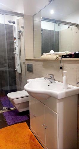 a bathroom with a sink and a toilet and a mirror at Appartement avec piscine a 150m des jardins Majorelle in Marrakech