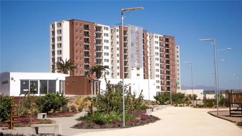 ein großes Wohnhaus mit Palmen in einem Park in der Unterkunft Hermoso departamento full equipado in Coquimbo