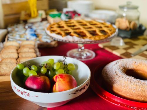 a table topped with a bowl of fruit and a pie at Casale Viridi - nel fresco delle colline Umbre in Narni