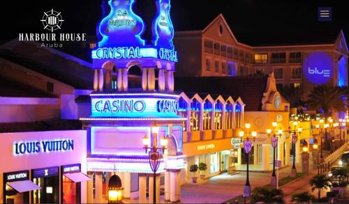 a city street at night with neon signs at Ocean View Condo overlooking the Caribbean Sea in Oranjestad
