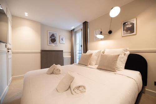 a bedroom with a large white bed with towels on it at MBM - Luxury home in marais in Paris
